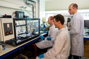 Members of the Malda lab working with a 3D bioprinter