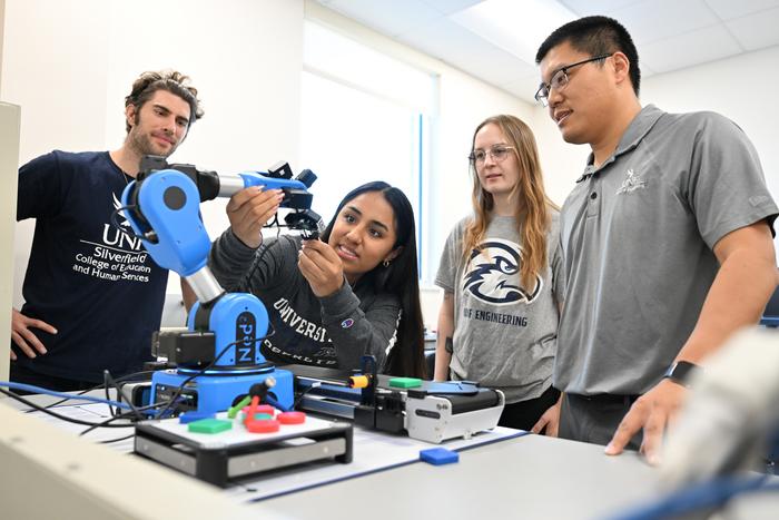 UNF advanced manufacturing students and faculty looking at printing equipment