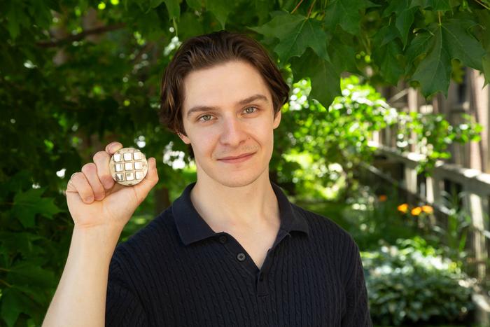 Ajay Talbot holds up samples of metal alloys made of nickel, cobalt and chromium