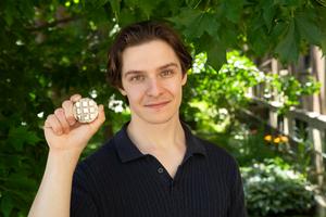 Ajay Talbot holds up samples of metal alloys made of nickel, cobalt and chromium