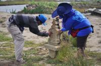 Project staff recording carved Muslim gravestone that was displaced by the 2004 Indian Ocean tsunami.