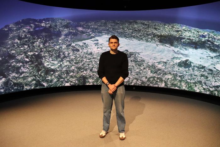 Dr Anthony Clarke in front of a 3D image of the Batavia wreck site. Credit - Curtin University