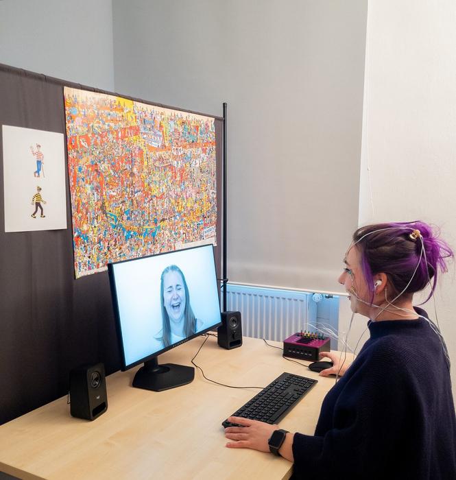 Test subject in the experiment: Electrodes on the skin measure the activity of the facial muscles. The colorful picture puzzle is intended to distract from the joke. Immediately after each joke, the test subject saw and heard a laughing person.