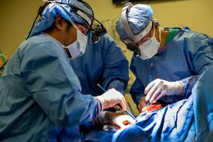 Dr. Chitaru Kurihara (left) and Dr. Ankit Bharat (right) operating on a patient, removing the damaged lungs and attaching an artificial lung.
