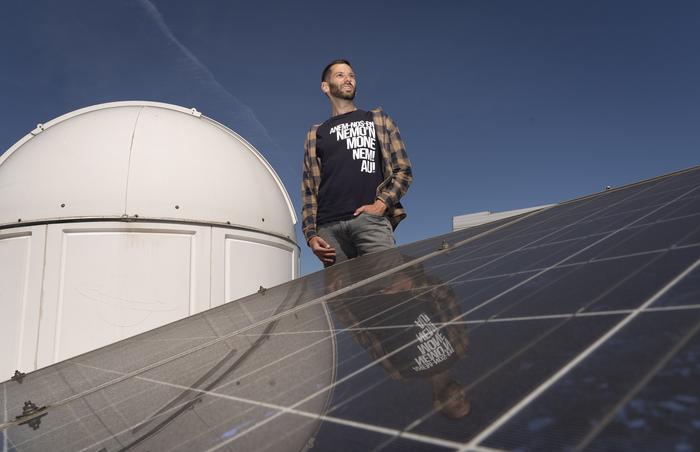 Alex Tro on the roof with photovoltaic panels