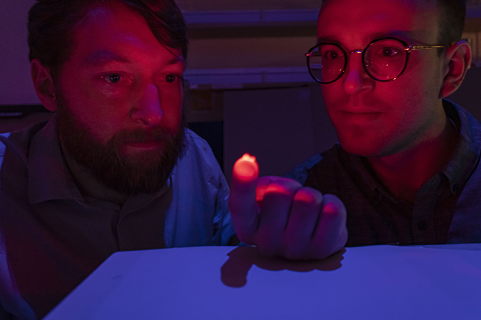 Philipp Gutruf and Jokubas Ausra with an optogenetic device.