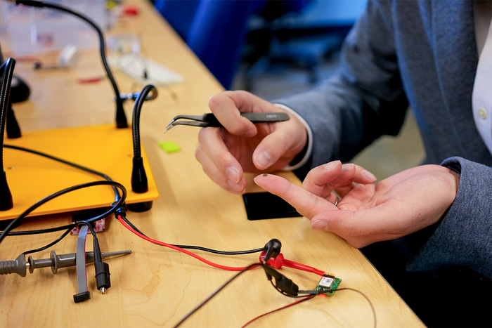 Xilin Liu holds a prototype of a neural implant chip