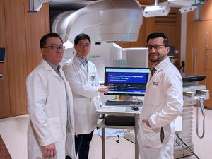 Study authors Drs. Mohamed Abazeed (right), Yirong Liu and Troy Teo (left) demonstrates a prototype AI tool that summarizes cancer pathology reports, shown here in a radiation oncology setting.