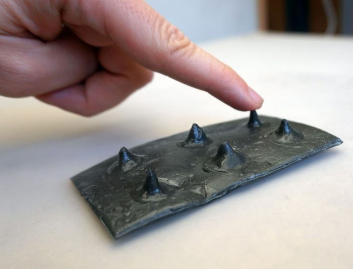 Sheet of material on which raised dots similar to Braille patterns have been created.