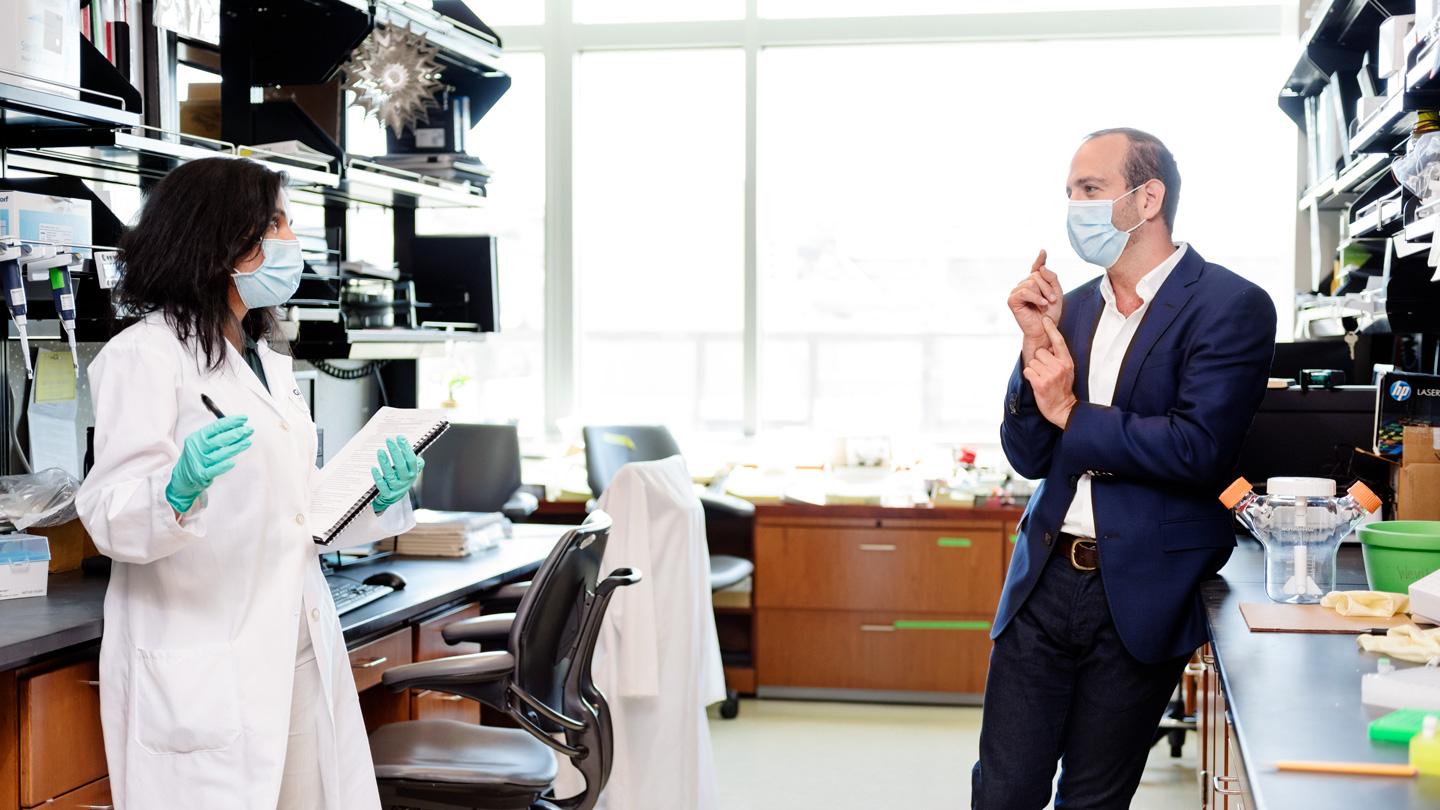 Leor Weinberger talking to Sonali Chaturvedi in the lab