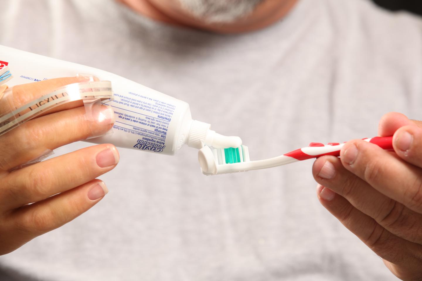 Keith Vonderhuevel Squeezing Toothpaste onto a Toothbrush