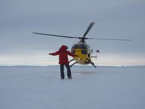 A helicopter lands at an ice core drilling site in Antarctica
