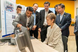 Minister for Digital Development and Information Mrs Josephine Teo (front right) looking at one of AUMOVIO’s 3D display solutions