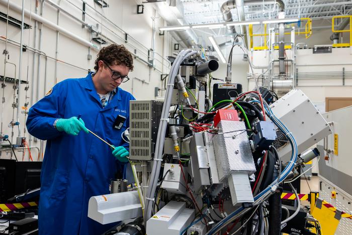 Mauseth making an adjustment to an instrument on the unshielded FIB-SEM to enable the next experiment.