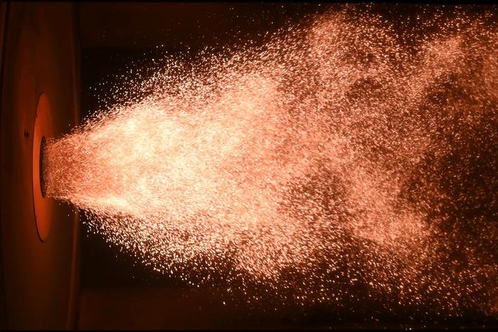 Iron dust flame at lab scale. For presentation purposes, the photo has been rotated by 90 degrees. (Photo: Janik Hebel, TU Darmstadt)