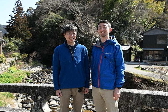 Hayashi and Kano stand before the stone-paved weir (Ishidatamizeki)