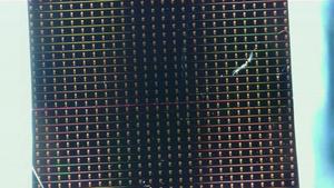 The researchers used waveguides—microscopic channels fabricated on a silicon wafer—to guide light. Long waveguides of varying widths can be seen on the chip, where a thin layer of organic molecules transforms light as it passes through
