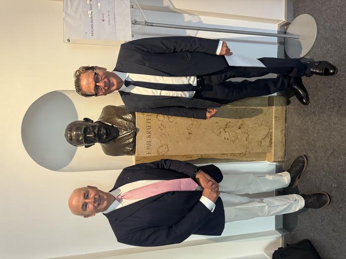 Professor Siegfried Kasper (right) with colleague Hans-Jürgen Möller standing beside the bust of Emil Kraepelin, the pioneering psychiatrist who transformed psychiatry into a scientific discipline.