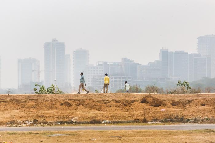 Men walk on a peripheral street of Gurgaon