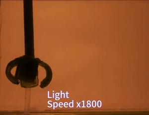 A soft robot arm grasps a small metal ball when exposed to light