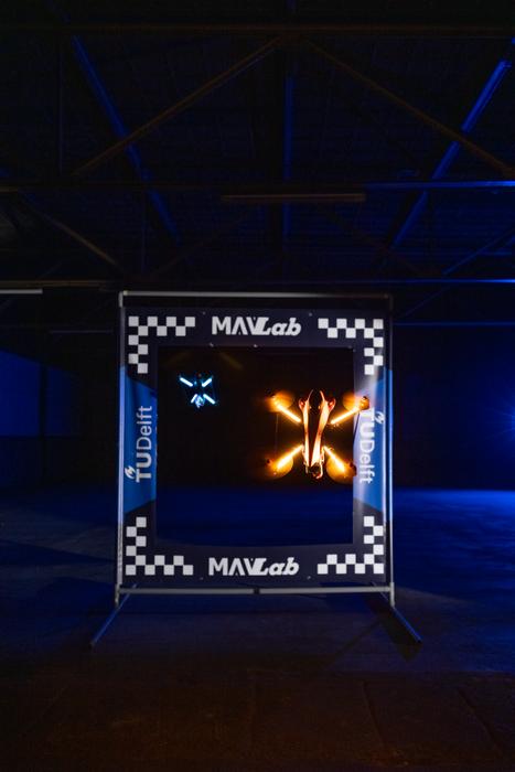 An autonomous racing drone flies through a gate during trials