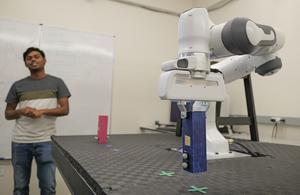 Robot regret photo - Graduate student and robotic arm