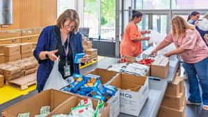 Cynthia Jenks joins colleagues in the effort to pack food bags for Second Harvest Food Bank