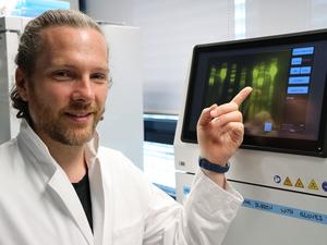 Andrew O’Donnell in front of a gel imaging system