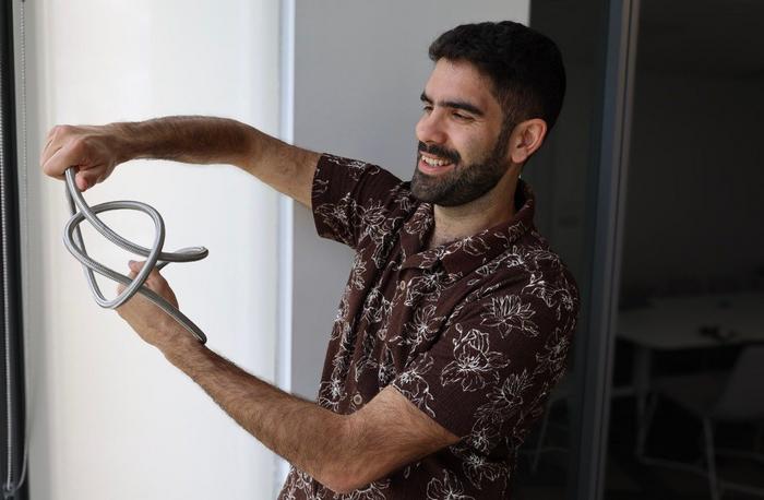 Evangelos Piliouras, a graduate student in physics, demonstrates a space curve.