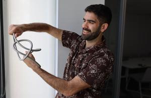 Evangelos Piliouras, a graduate student in physics, demonstrates a space curve.