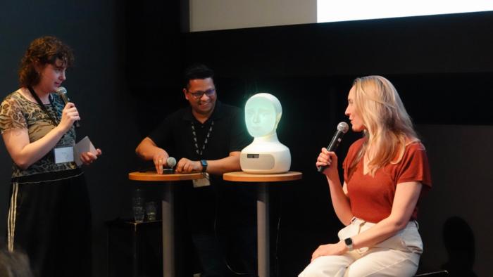 Moderator, researchers and robot on stage