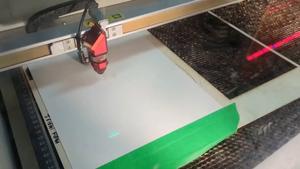 A laser cutter is used to create a parachute from a sheet of plastic or paper.