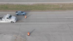 Drone footage of an electric truck charging while driving on a highway