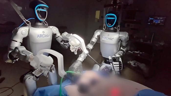 Two humanoid robots performing a laparoscopic surgery