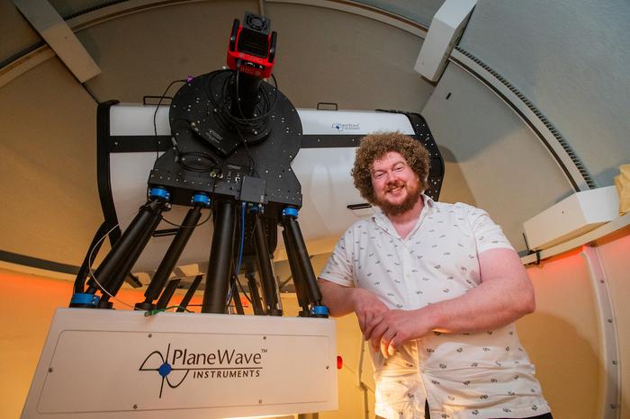 Dr Ross Donaldson stands next to the new telescope.
