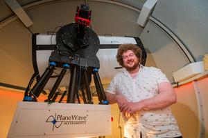 Dr Ross Donaldson stands next to the new telescope.