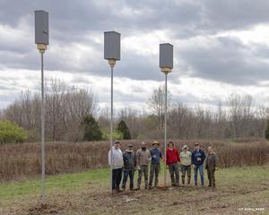 Joy O'Keefe (third from right) and the research team pose next to bat boxes.