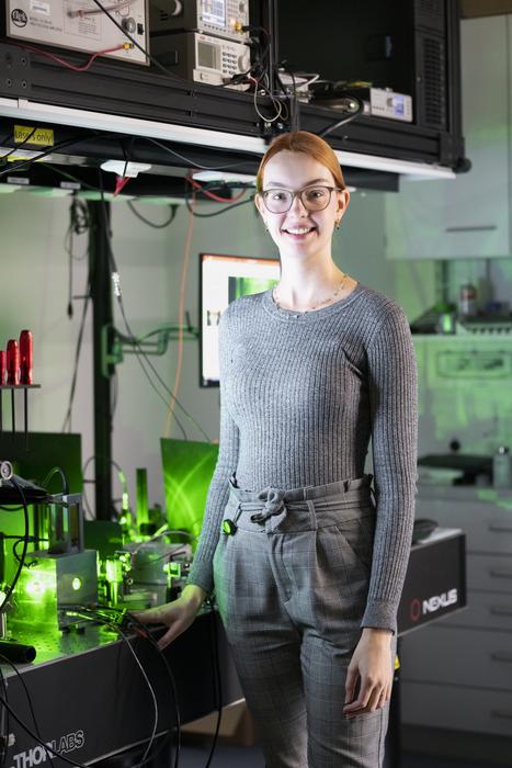 ISTA PhD student Andrea Stöllner in front of her experimental setup.