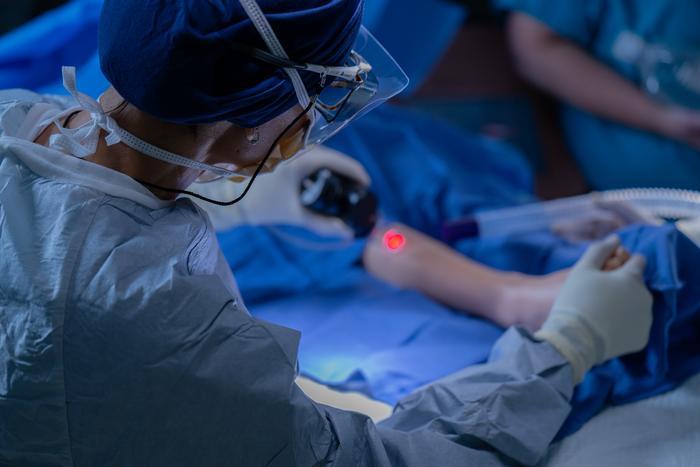 Dr. Higginson performing laser treatment on patient.