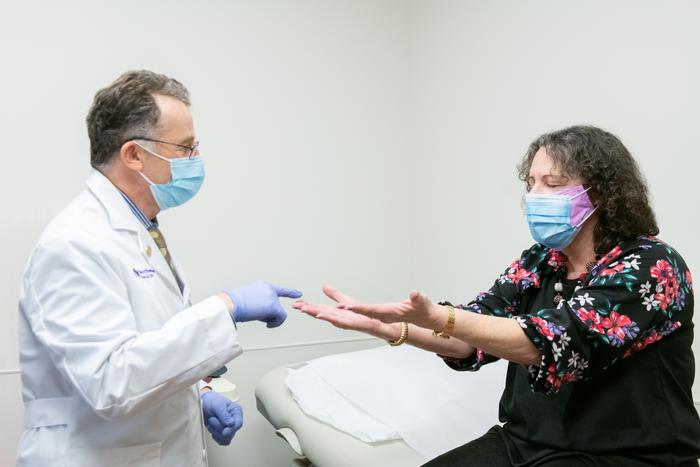 Dr. Igor Koralnik meets with a patient in the Comprehensive COVID-19 Center at Northwestern Medicine