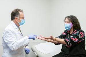 Dr. Igor Koralnik meets with a patient in the Comprehensive COVID-19 Center at Northwestern Medicine