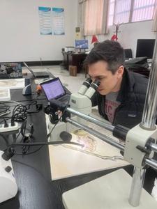 Alexander Clark, assessing the Plumadraco fossil under a microscope.