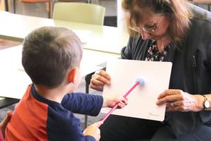 Child pointing at WatDAT board