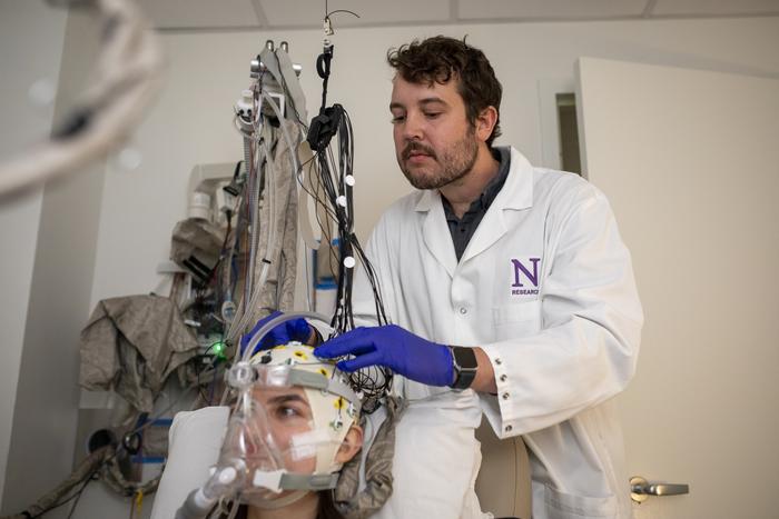 Study author adjusts participant's EEG cap