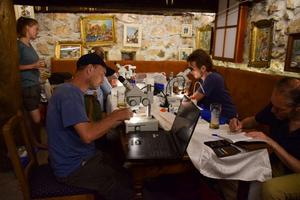Participants of the taxon expedition studying snails in the makeshift field lab near the Komarnica Canyon.
