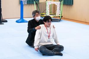 Associate Professor Satoshi Koga of the Faculty of Human-Environment Studies explains to a student how to relieve stress through Dohsa-hou.