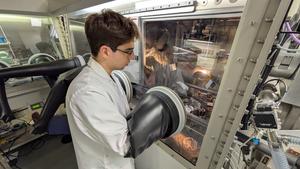 Arnaud Petit, a PhD student and co‑author of the study, prepares a sample on which a thin organic film will be deposited using vacuum thermal evaporation.